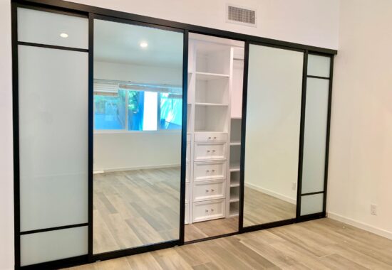 Modern room with sliding interior glass doors and built-in white shelving units.