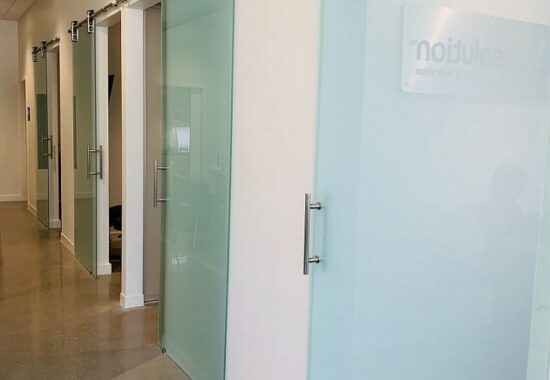 Frosted interior glass doors along a corridor in a modern office setting.