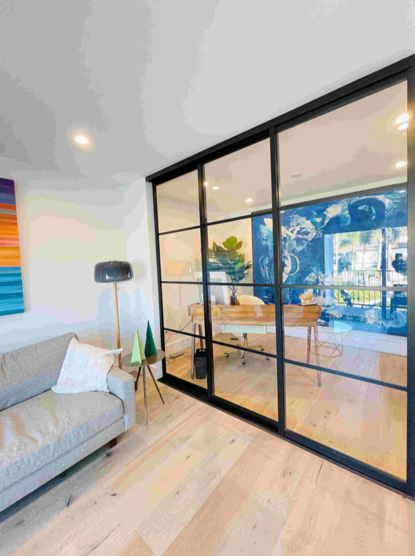 Glass divider separating a home office from the living room