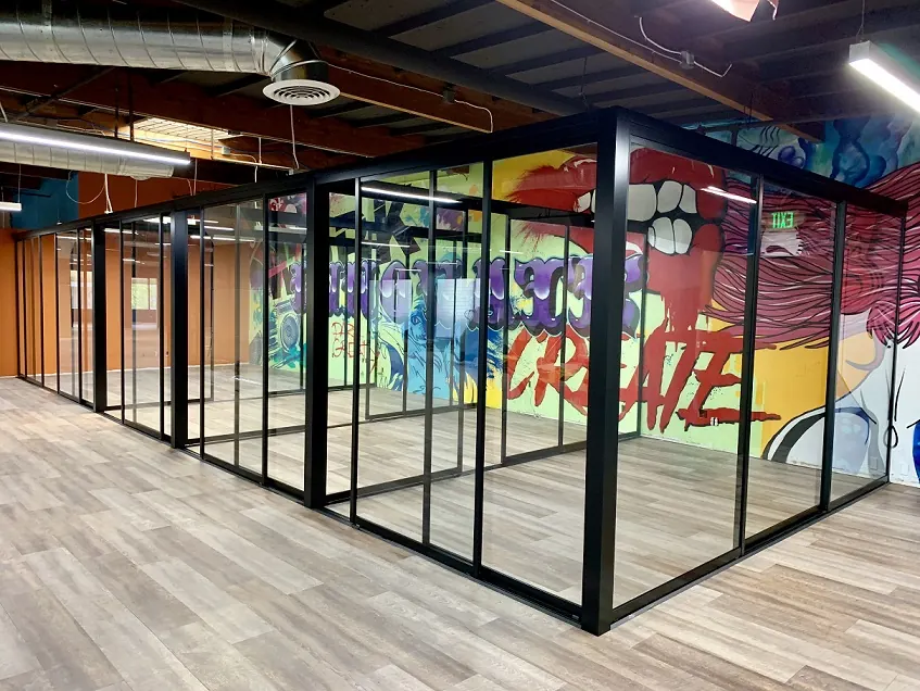 Glass office partition with black-framed entry doors